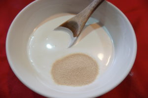 將椰漿微波30秒，加入速發酵母粉，攪拌均勻