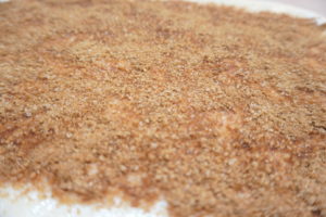 在麵團上塗上適量椰子油，再撒上滿滿的砂糖與肉桂粉，上面預留0.6公分以便捲起。