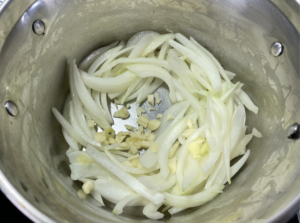 將奶油放入鍋中，開中小火，再將洋蔥與大蒜放入，炒至洋蔥略微透明